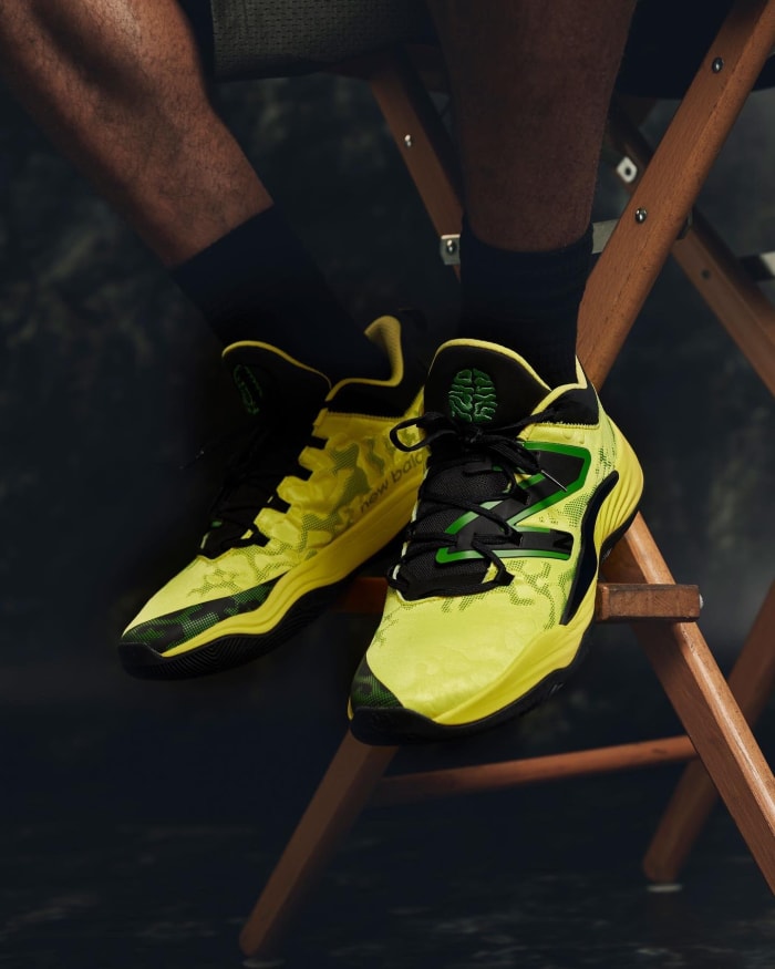 View of yellow, green, and black New Balance shoes.